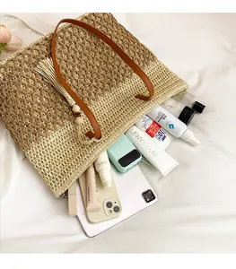 Detail of spacious interior showing a two-tone woven straw tote bag with brown leather handles