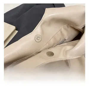 Détail du fermoir magnétique et des finitions dorées sur un sac fourre-tout crème