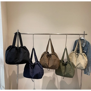 Detail of multi-color drawstring tote bags in nylon with functional side pockets