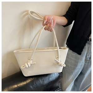 Détail du sac cabas blanc crème avec poignées nouées et texture en cuir PU lisse