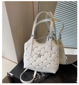 Detailansicht der weißen Stepptasche mit Metallnieten und Strass-Stern-Schnalle