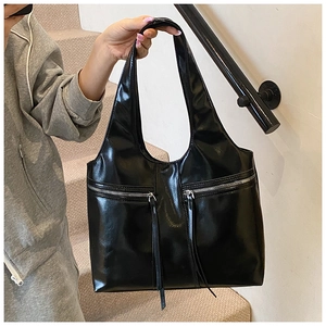 Détail du grand sac cabas noir brillant avec double fermeture éclair et longs pompons