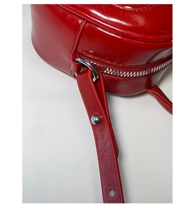 Close-up of red retro polka dot handbag with silver metal zipper and rivet details