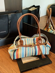 Colorful striped woven straw baguette bag with brown leather handles for beach vacation