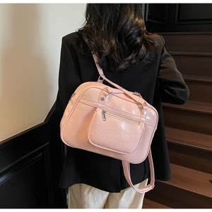 Detail of pink PU leather school bag showing the Noronoro logo and zipped front pocket