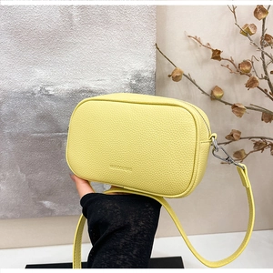 Dettaglio della borsa a tracolla giallo limone in pelle martellata con dettagli argento