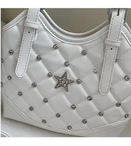 Dettaglio della borsa in ecopelle bianca trapuntata con rivetti e cristallo a forma di stella