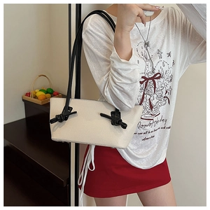 Détail du sac cabas minimaliste avec bandoulières noires nouées sur cuir crème
