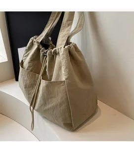 Detailed view of khaki nylon tote bag with drawstring closure and large capacity design