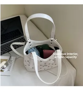 Vista dettagliata dell'interno capiente della borsa bianca trapuntata con cellulare