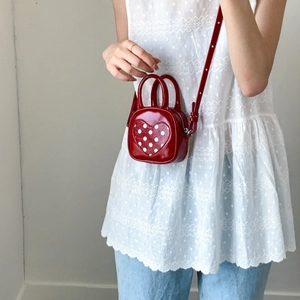 Mini red polka dot heart handbag for girls, featuring adjustable strap and dual handles