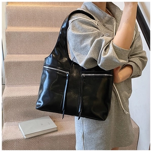Détail du sac à bandoulière en cuir PU noir avec double fermeture éclair et lanières