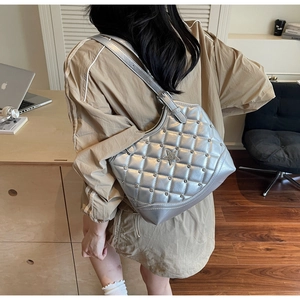 Detail der silbernen gesteppten Handtasche mit Sternnieten und Y2K-Ästhetik