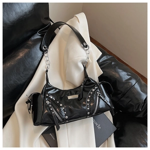 Vue détaillée d'un sac à main noir brillant style punk avec rivets et bandoulière chaîne