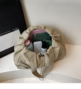 Detail view of khaki drawstring tote bag showing spacious interior with tablet and items