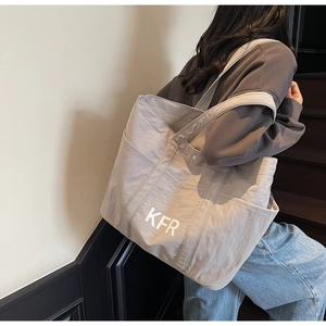 Practical large capacity khaki tote bag with wide strap and KFR print shown on shoulder