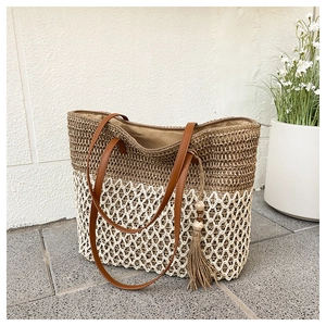 Detail of woven straw tote bag featuring two-tone texture and stylish beaded tassel