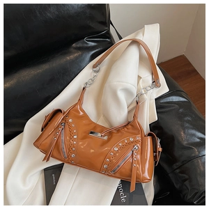 Détail des rivets argentés et fermetures éclair sur le sac à main marron brillant