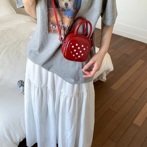 Close-up of red PU leather bucket bag featuring a polka dot heart and shoulder strap