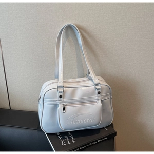 Close-up of light grey glossy bag with zip pocket and polished silver hardware