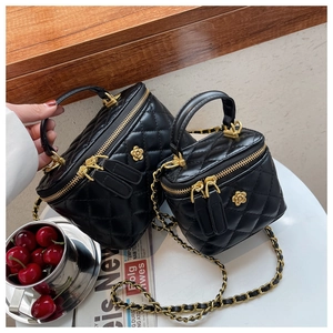 Detalle de bolsos acolchados negros con cadenas doradas y logotipo floral metálico