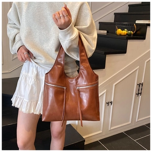 Détail du sac cabas marron caramel avec doubles fermetures éclair et longs pompons