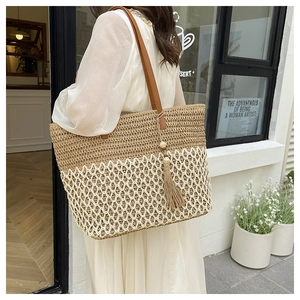 Detail of hand-woven straw tote with hollow diamond pattern and beaded fringe tassel