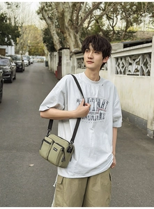 Photo de rue d'un sac bandoulière homme en nylon vert olive clair à plusieurs poches