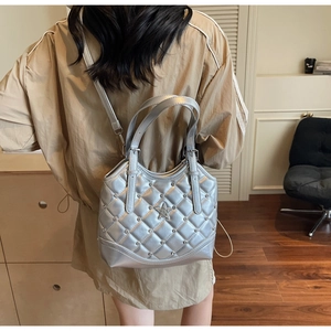 Detailansicht der silbernen Stepptasche mit Diamantstern-Emblem und Nieten-Akzenten