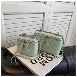 Detail of light mint quilted box bags with silver chain and floral zipper pullers