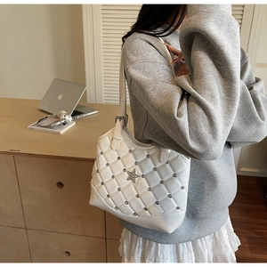 Dettaglio della borsa in pelle bianca trapuntata con stella in metallo e tracolla
