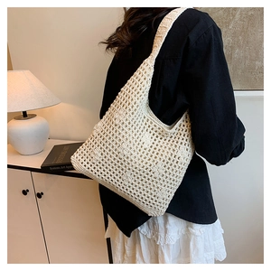 Detailed view of bohemian hollow-out crochet pattern on this off-white woven tote bag
