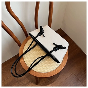 Détail du nœud de bandoulière contrasté sur le cabas beige minimaliste texturé