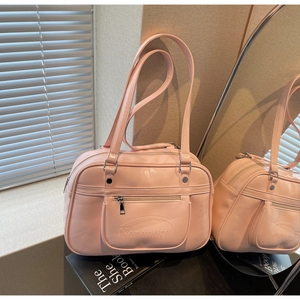 Detailed view of pink glossy PU shoulder bag featuring front zipper pocket and silver hardware