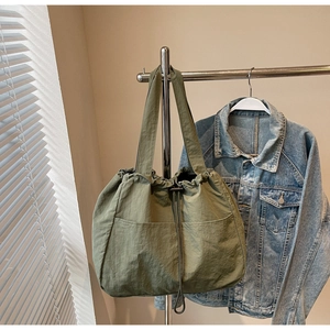 Detail of army green nylon tote bag with drawstring closure and large capacity design