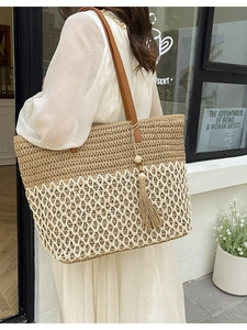 Summer straw tote bag with dual-tone woven pattern and leather straps for beach holidays