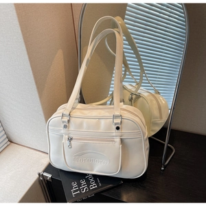 Detail view of cream PU leather boston bag with silver hardware and front zip pocket