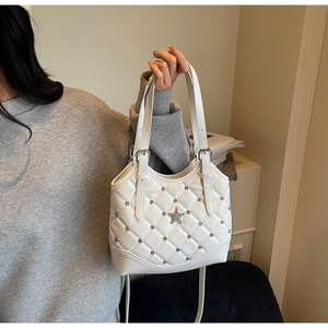 Detailaufnahme einer weißen gesteppten Schultertasche mit Stern-Metallverzierung