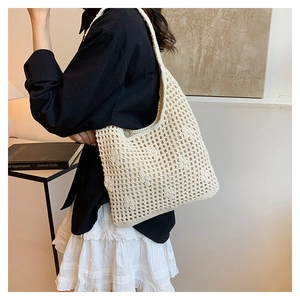 Detail of a cream crochet tote bag showing hollow-knit texture and large capacity style