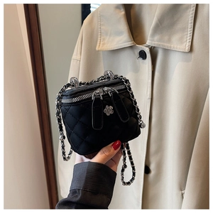 Detail der schwarzen gesteppten Mini-Tasche mit einem silbernen Kamelien-Reißverschluss