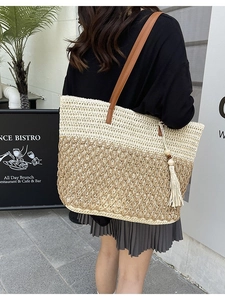 Large woven straw tote bag with two-tone design and leather handles for beach holidays