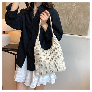Detailed close-up of a beige crochet tote bag featuring intricate floral woven patterns