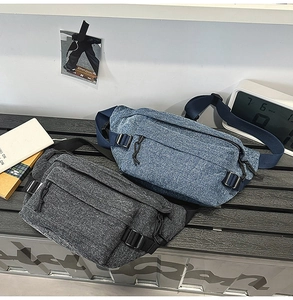 Macro detail of washed denim chest bags featuring multiple zipped pockets and nylon straps