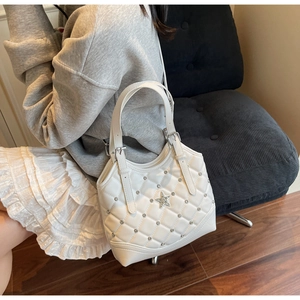 Detail einer weißen Stepptasche mit Sternkristallen und Metallschnalle am Trageriemen