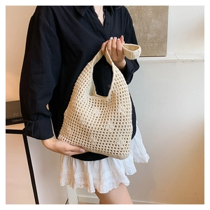 Close-up of beige crochet tote bag showing hollow-out woven texture and wide handle