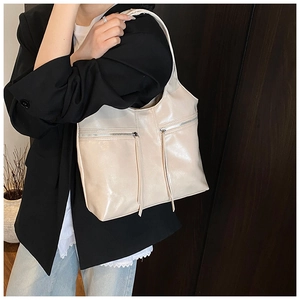Détail du sac à bandoulière blanc cassé en cuir ciré avec tirettes de zip décoratives