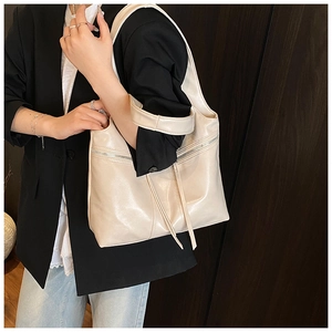 Détail du grand sac cabas beige en similicuir avec cordon de serrage et zip métallique