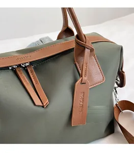 Detail of army green tote with brown leather handles and premium metal zipper hardware