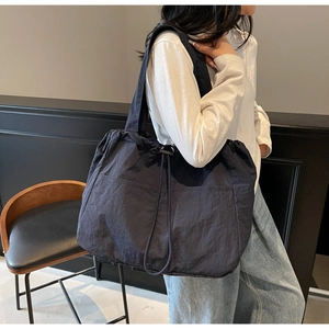 Detail of spacious nylon tote bag with drawstring closure and wide shoulder strap for daily use
