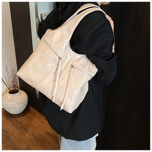 Détail du grand sac cabas beige avec de longues tirettes de fermeture éclair en métal